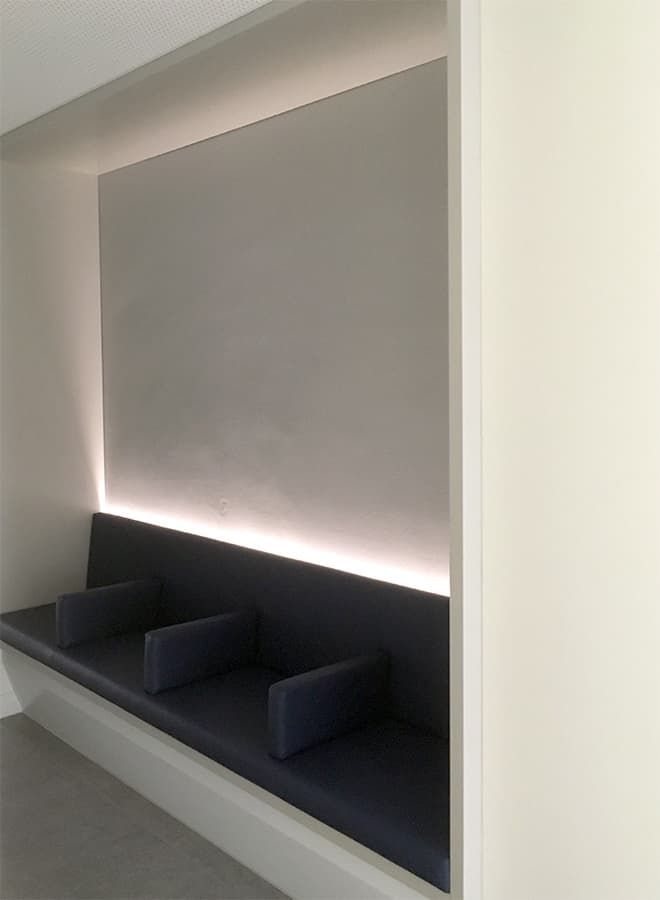 Gepolsterte Sitzbank in einer Wandnische mit indirekter Lichtfuge.