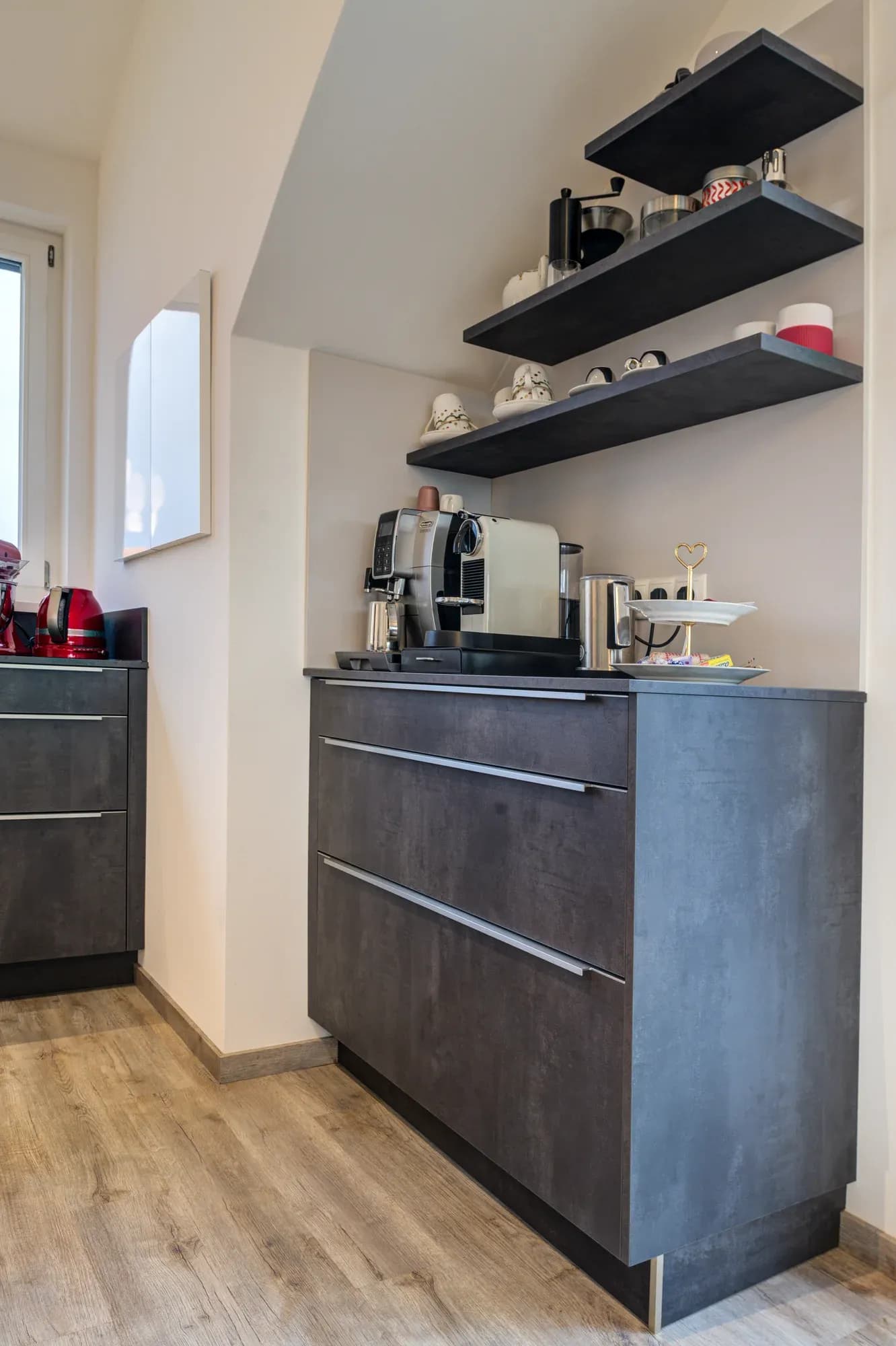 Sideboard in Beton-Optik mit offenen schwarzen Regalen im angrenzenden Essbereich.