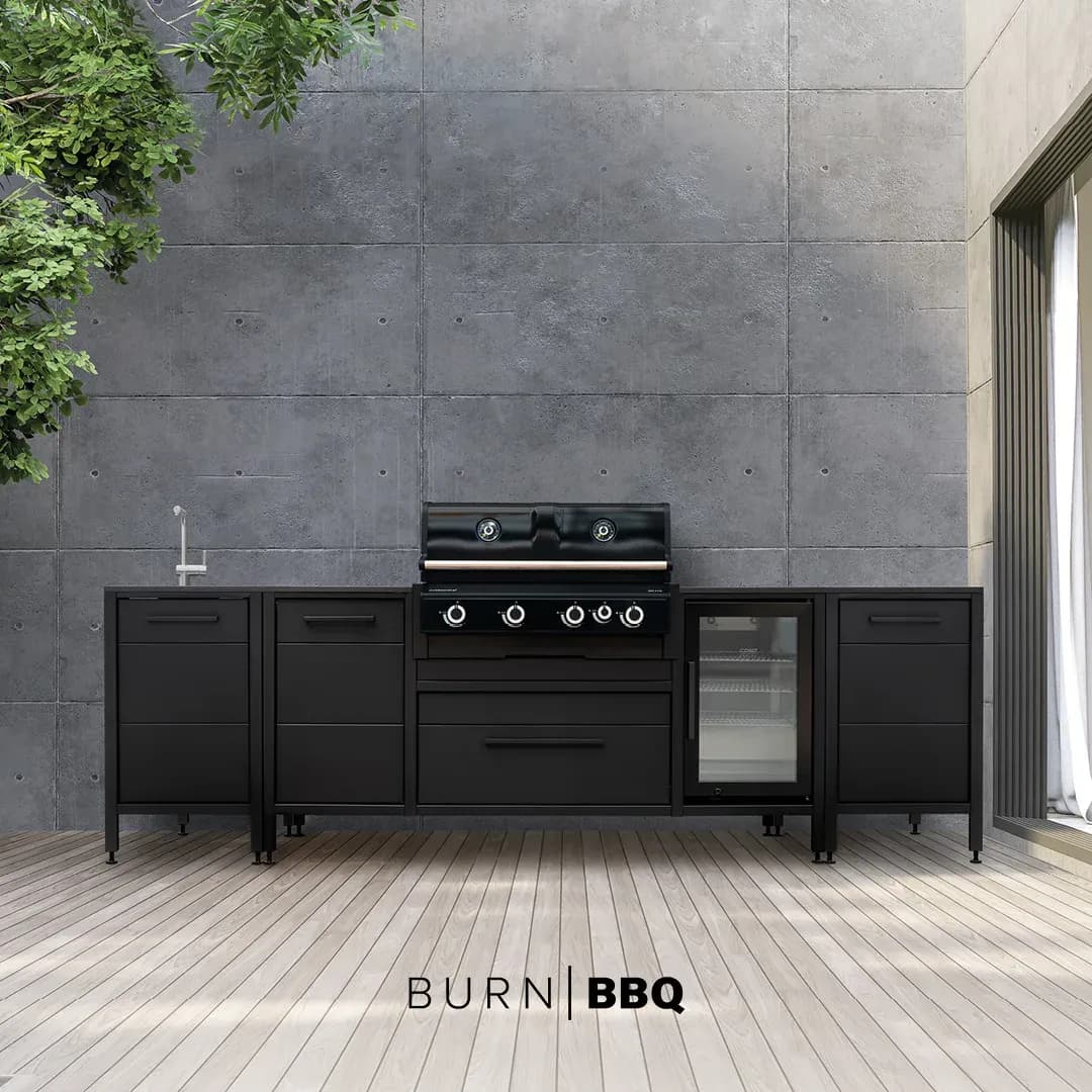 Anthrazitfarbene BURN-BBQ-Outdoor-Küche mit Gasgrill, Getränkekühlschrank und Spüle vor einer Betonwand