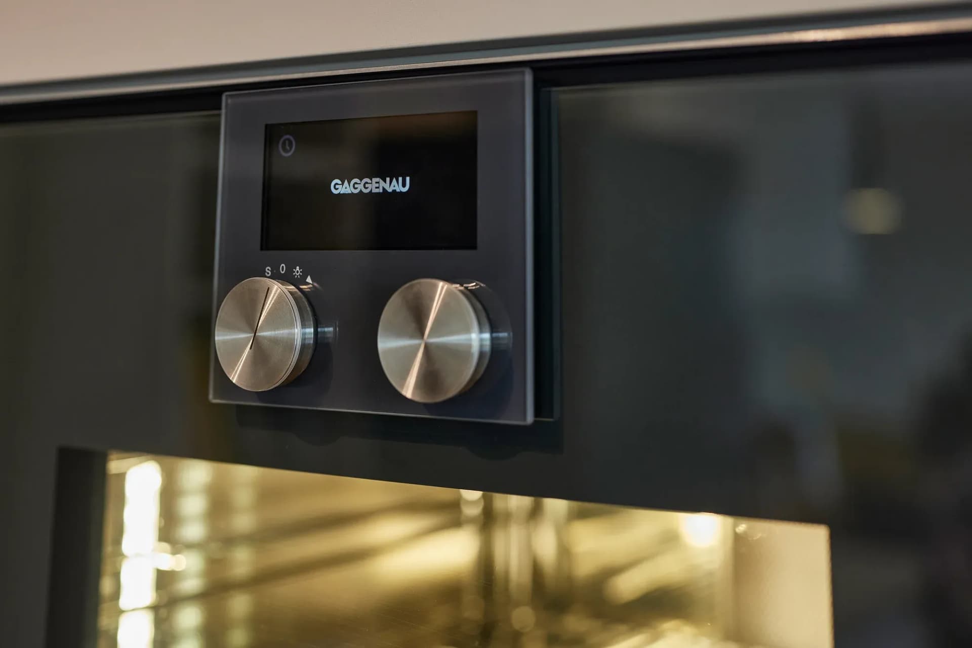 Nahaufnahme des Bedienfelds eines Gaggenau-Backofens mit Edelstahl-Drehknöpfen.