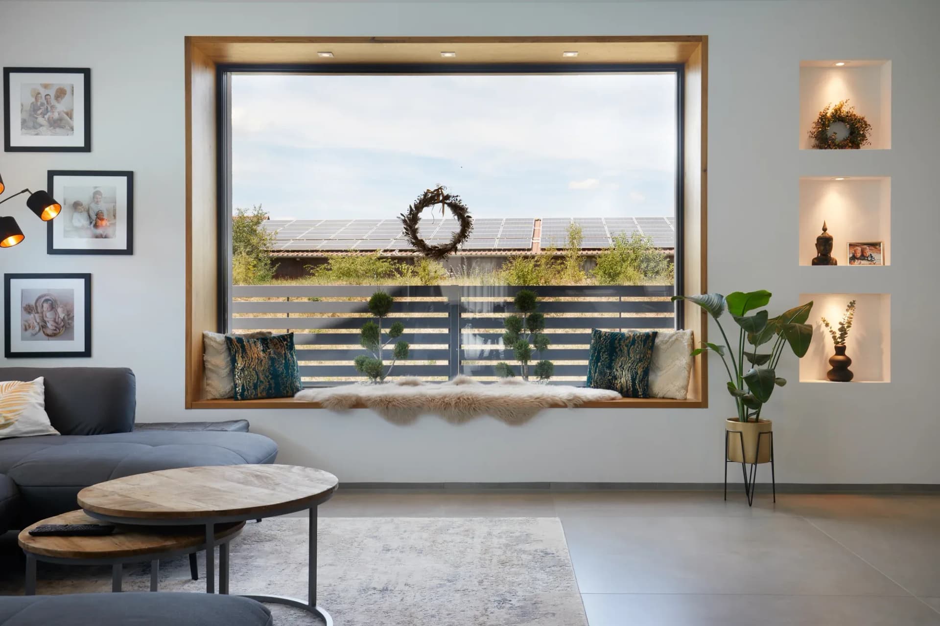 Sitzfenster aus Eiche mit Kissen, eingefasst von beleuchteten Wandnischen im Wohnzimmer