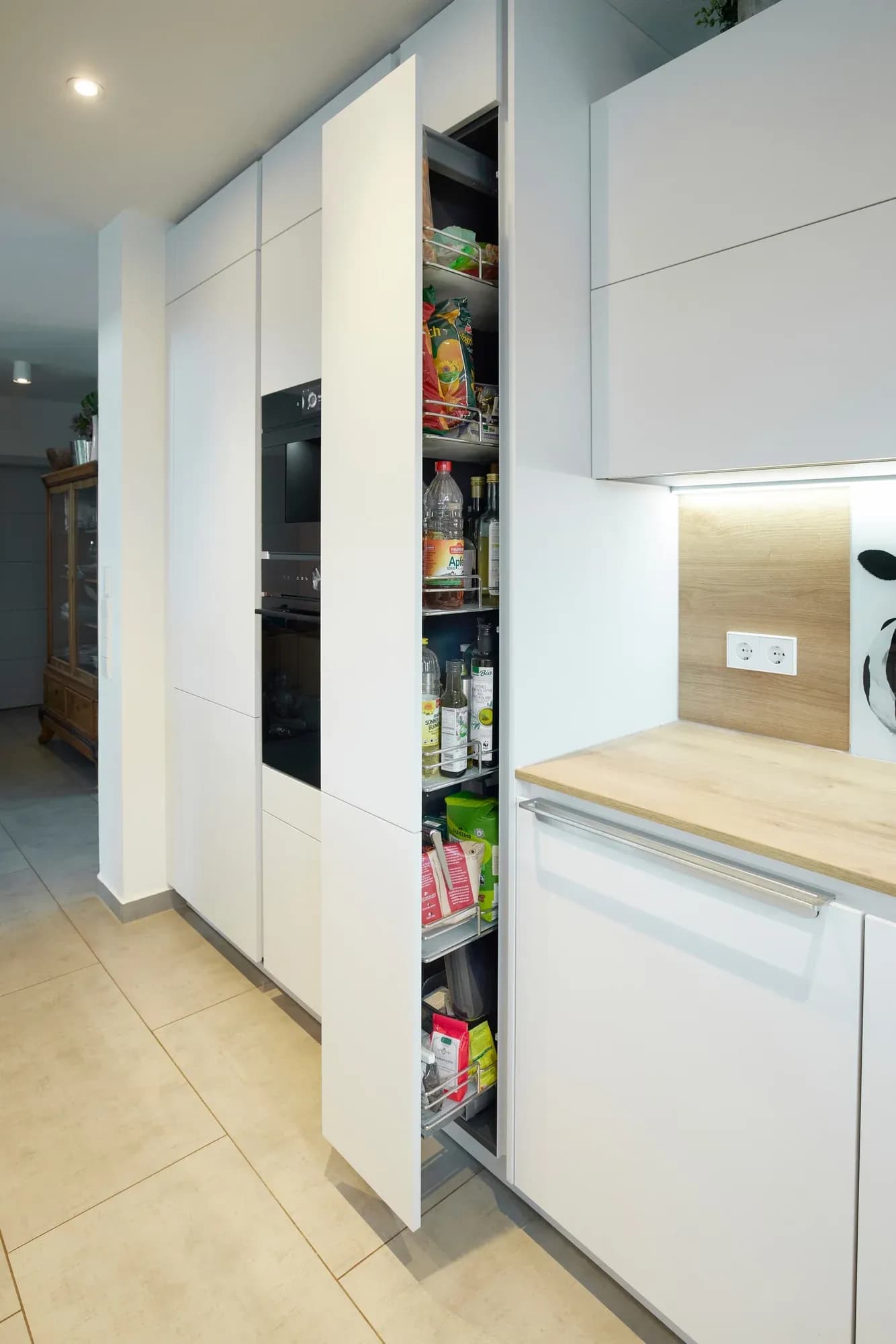 Hoher Apothekerauszug, voll ausgezogen mit Vorräten, neben dem Hochschrank mit Backofen.