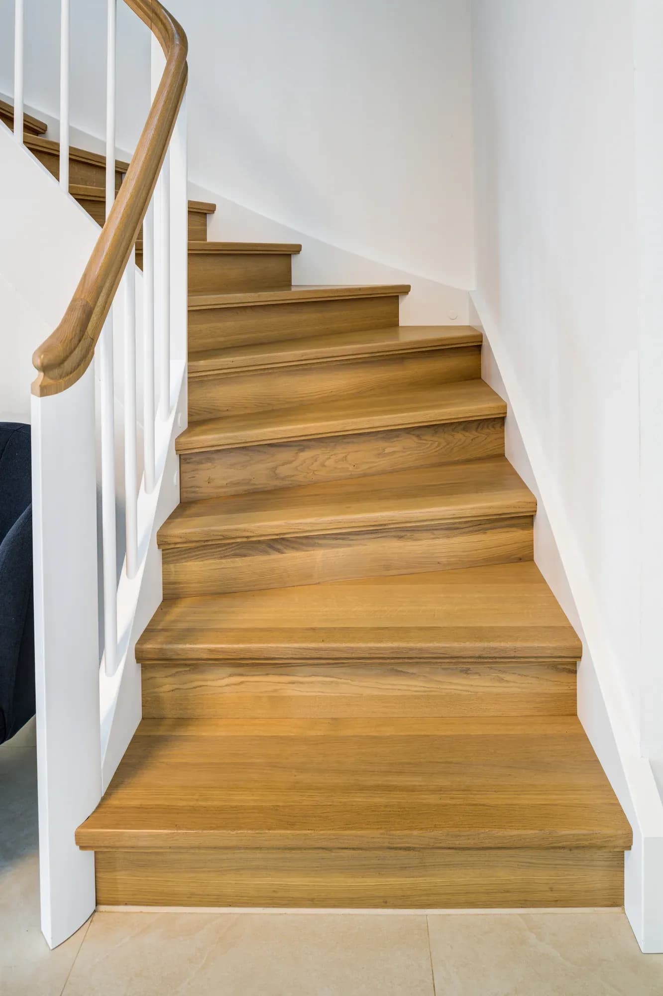 Hölzerne Trittstufen auf weiß gefasster Wange, Blick die Treppe hinauf
