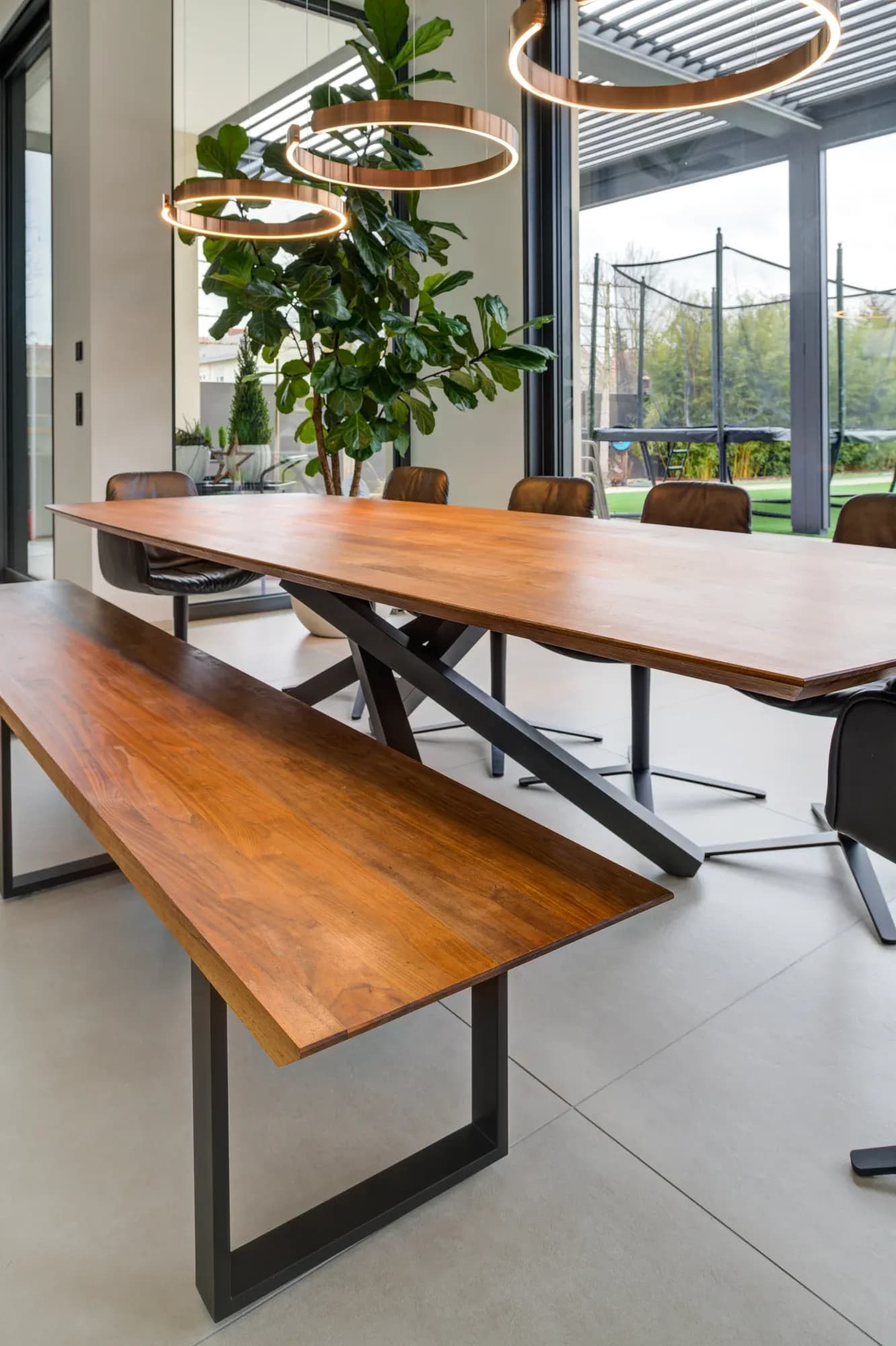Massive Holztafel mit Baumkante und passender Sitzbank unter Ring-Pendelleuchten