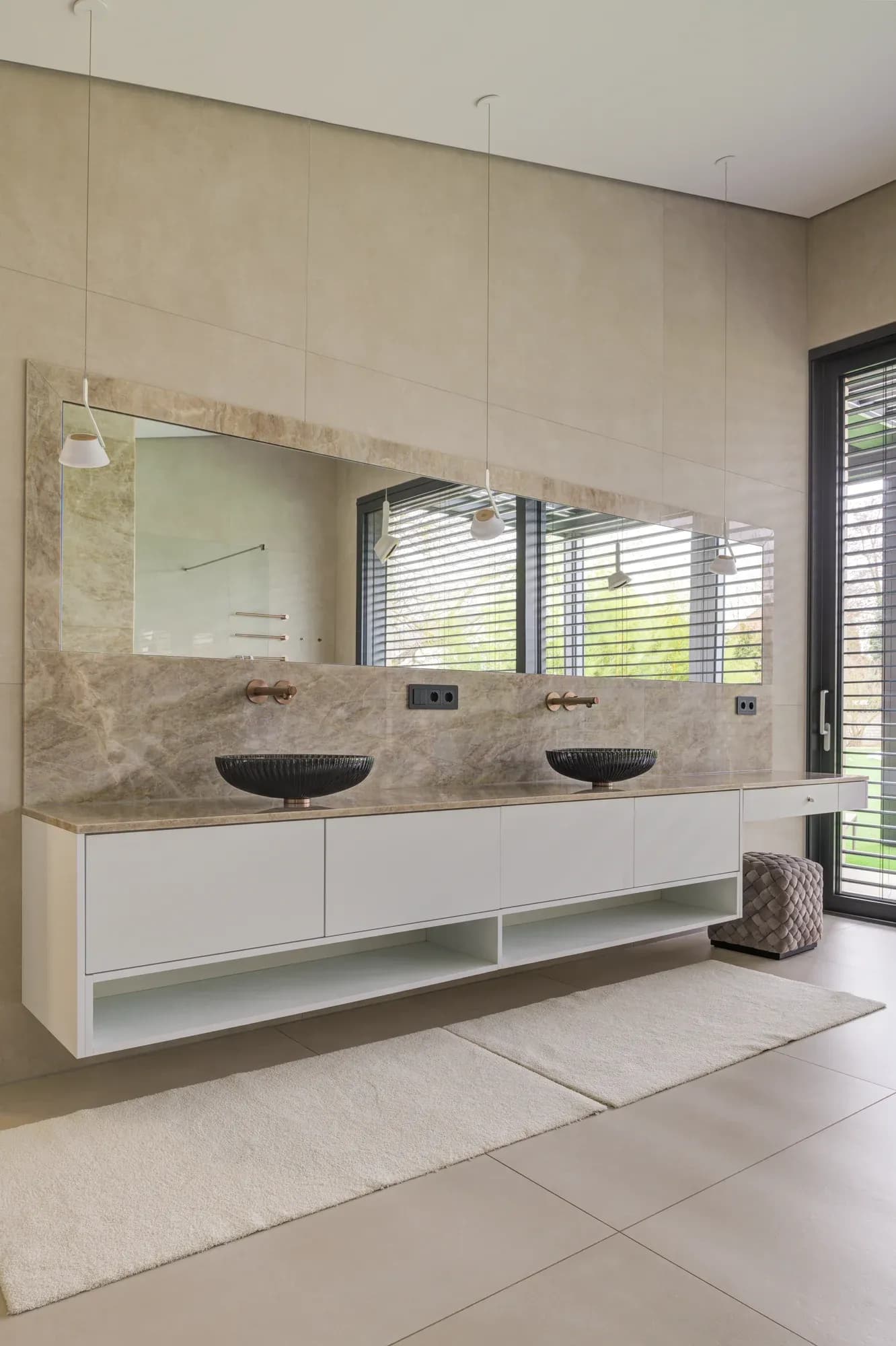 Doppelwaschtisch mit zwei steinernen Aufsatzschalen vor breiter Spiegelwand
