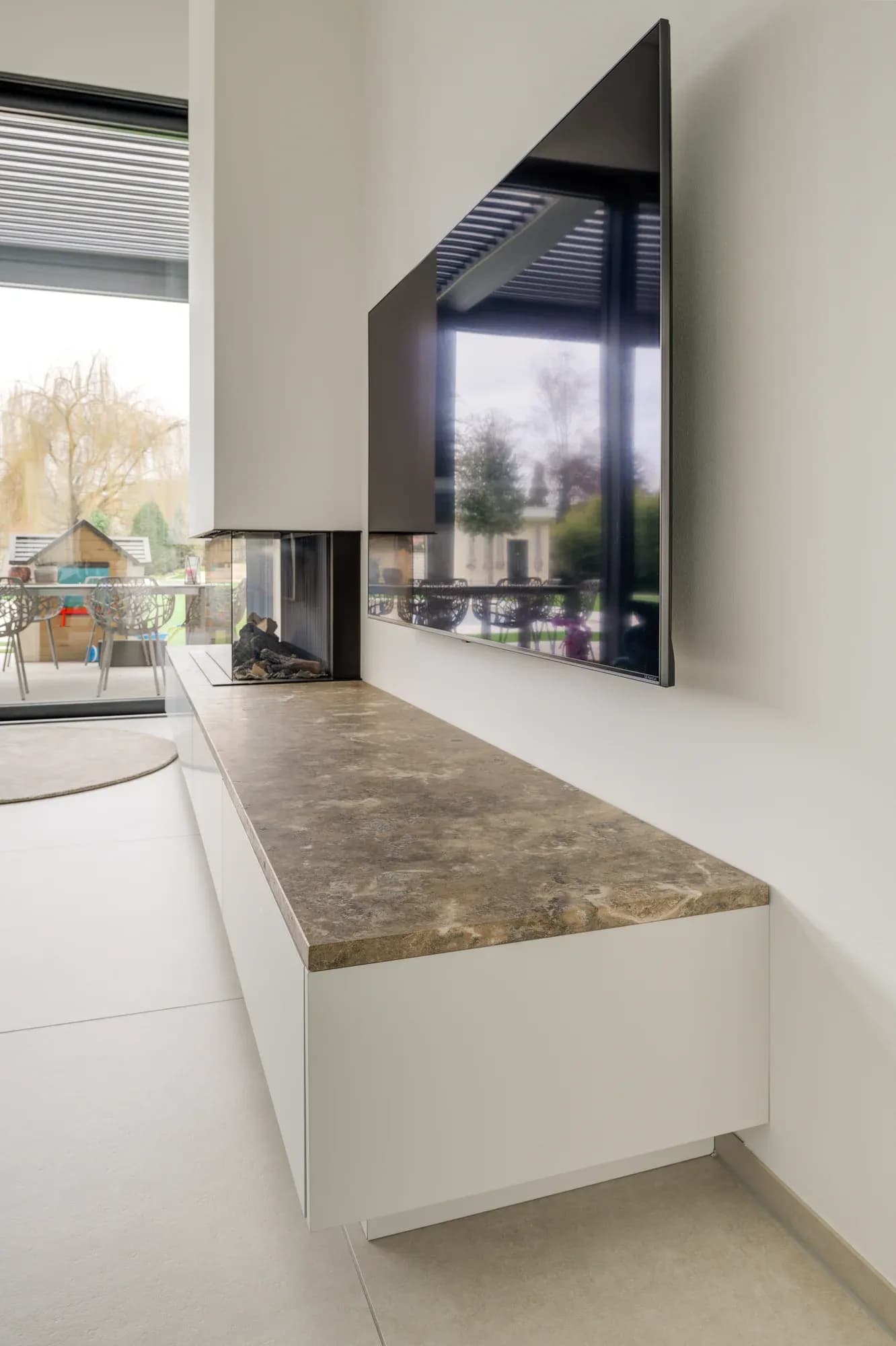 Steinerne Deckplatte eines Sideboards, bündig zum Eckkamin geführt