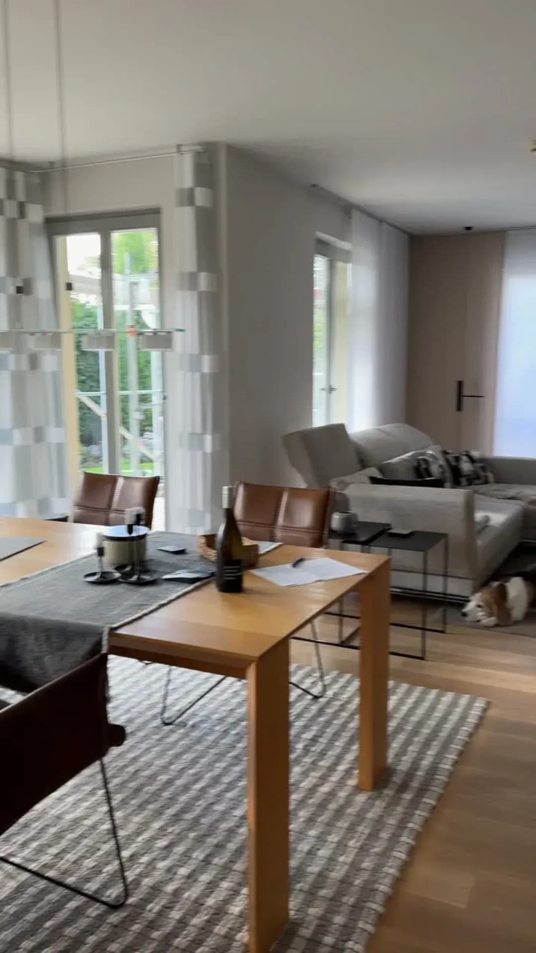 Vorher: der Wohn- und Essbereich mit hellem Holztisch und grauem Sofa vor dem Umbau.