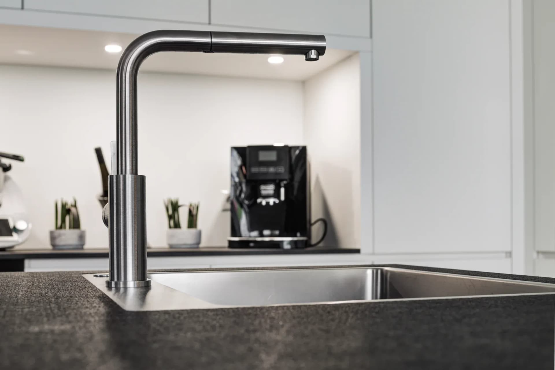 In eine mattweiße Hochschrankzeile bündig eingelassene Miele-Backöfen mit schwarzer Glasfront