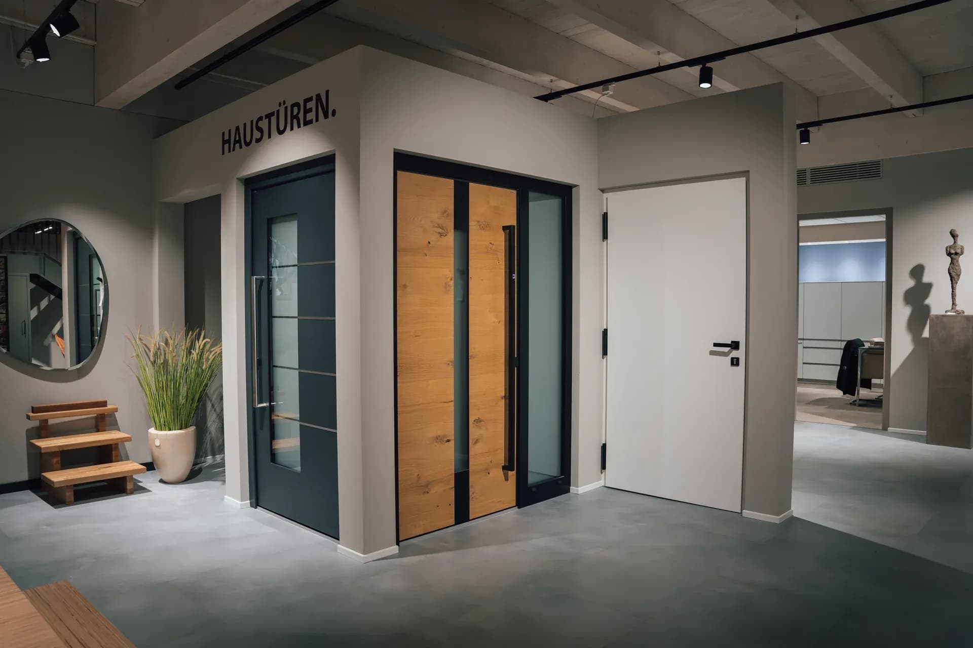 Haustüren-Koje in der Frey-Ausstellung: drei Haustüren in Anthrazit mit Glasstreifen, in Eiche mit Glas-Seitenteil und in Weiß
