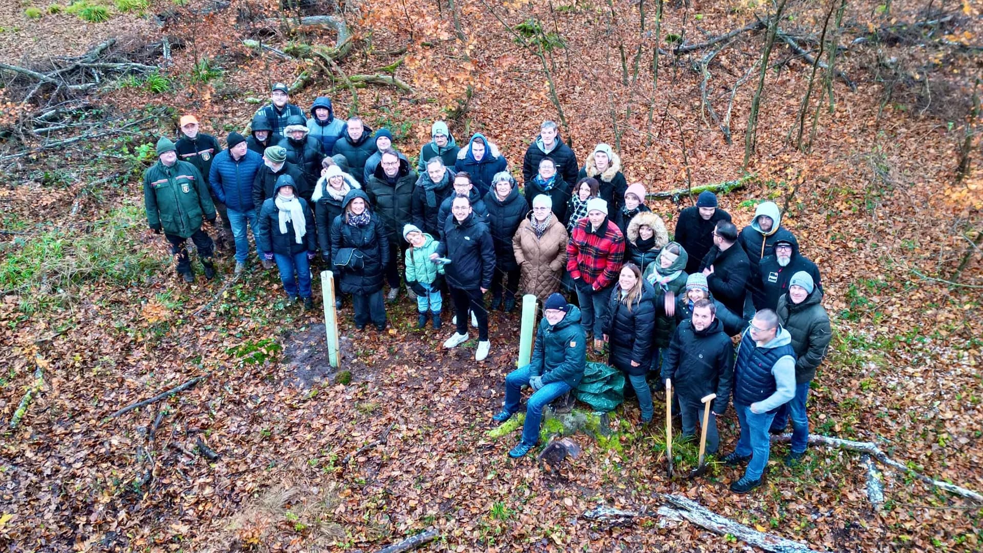 Das Frey-Team von oben im Bienwald bei der Baumpflanzaktion, zwischen frisch gesetzten jungen Bäumen mit Wuchshüllen.