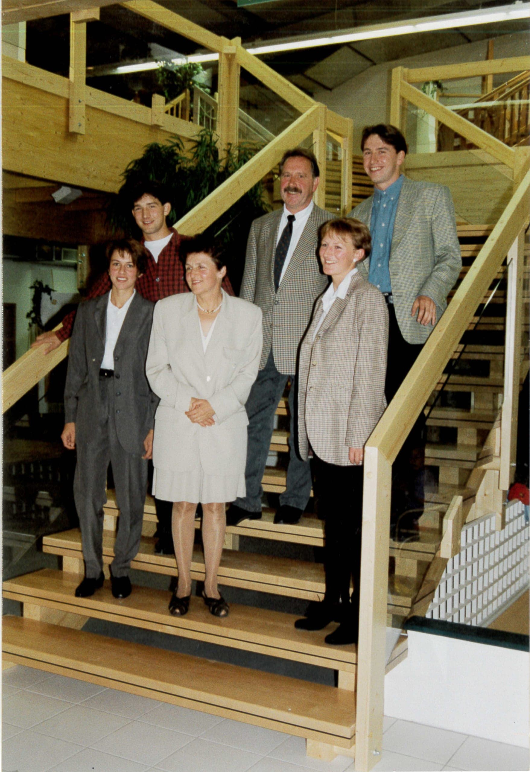 Sieben Personen auf der hellen Holztreppe im neu eröffneten Ausstellungszentrum Kandel am 6. September 1994, umgeben von der offenen Holzkonstruktion mit Galerie.