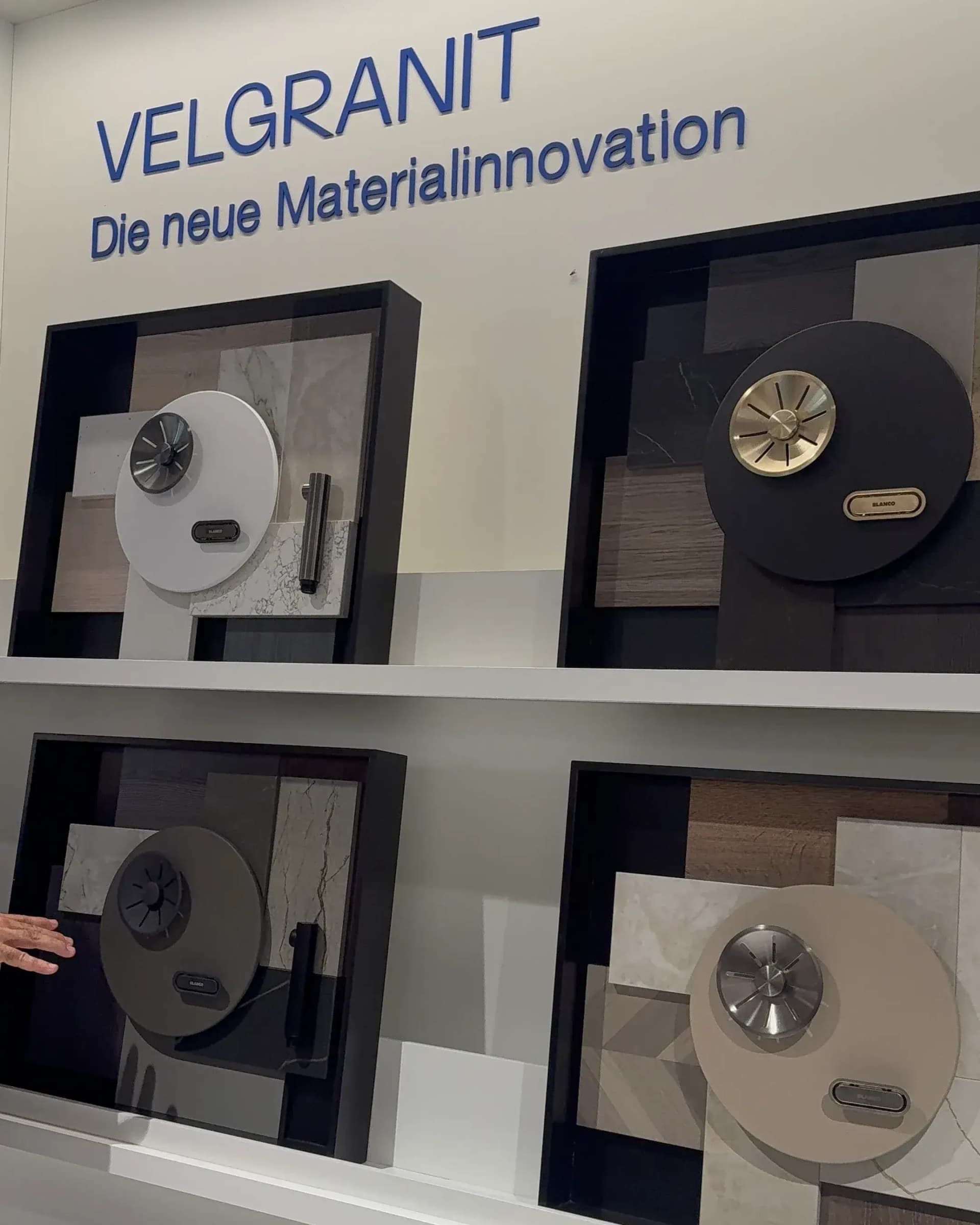 Bei Blanco auf Gut Böckel auf der Küchenmeile 2026: Musterwand zum Werkstoff VELGRANIT mit vier Farbkombinationen aus runden Beckenmustern mit Ablauf und Arbeitsplattenmustern.