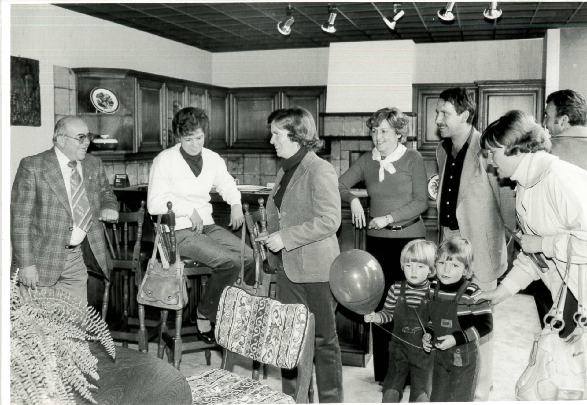 Gäste bei einer Ausstellungseröffnung in Schweighofen, Schwarz-Weiß: Familien im Gespräch, zwei Kinder mit Luftballons.