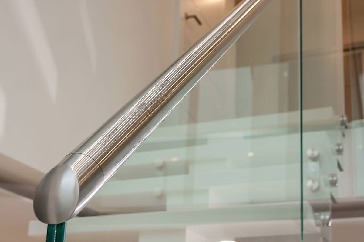 Moderne offene weiße Treppe mit Glaswand